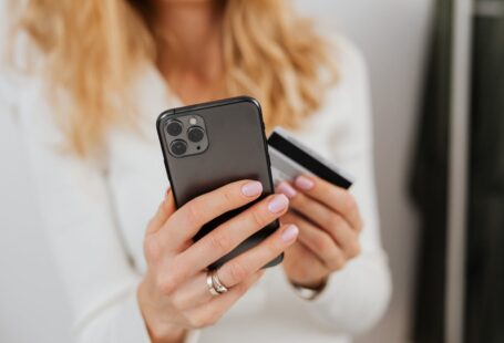 close-up-shot-of-a-person-holding-a-credit-card-and-a-smartphone